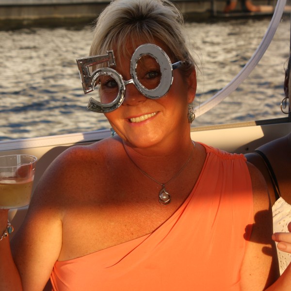 a person wearing glasses holding a glass of wine