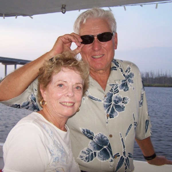 a person in sunglasses standing in front of a body of water