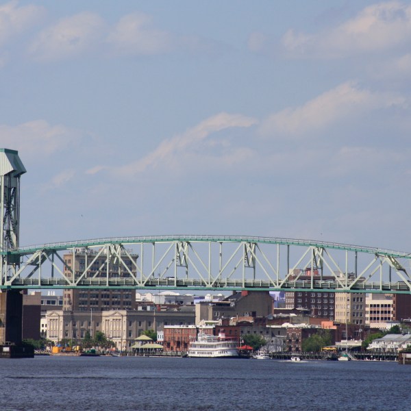 a bridge over a river with a city in the background