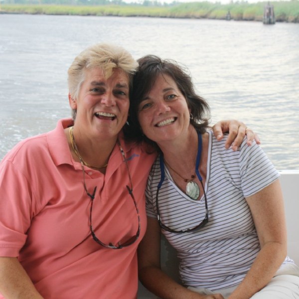 a man and woman sitting next to a body of water