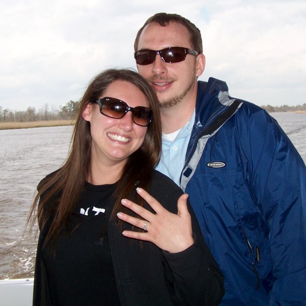 a person wearing sunglasses standing next to a body of water