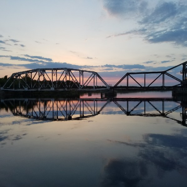 a train crossing a bridge over a body of water