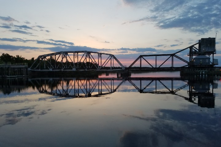 a train crossing a bridge over a body of water
