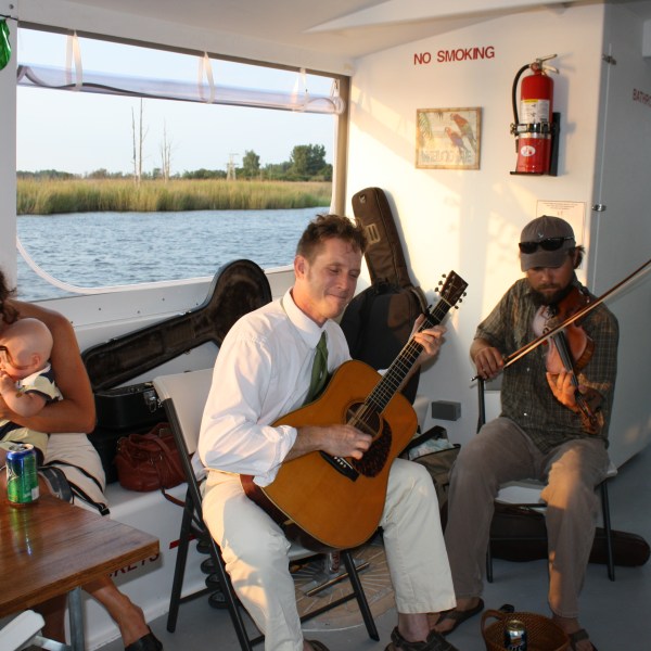 a group of people sitting at a table with a guitar