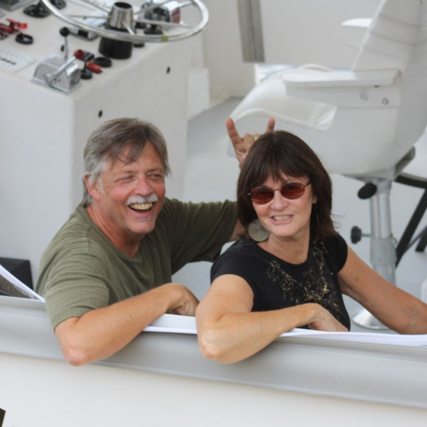 a man and woman sitting next to a sink