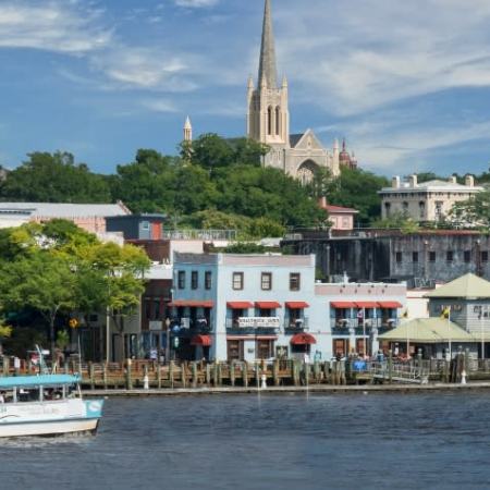 a small boat in a large body of water in front of a building