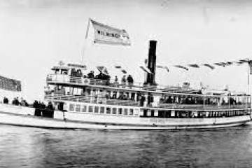 Vintage steamboat with flags and passengers on open water.